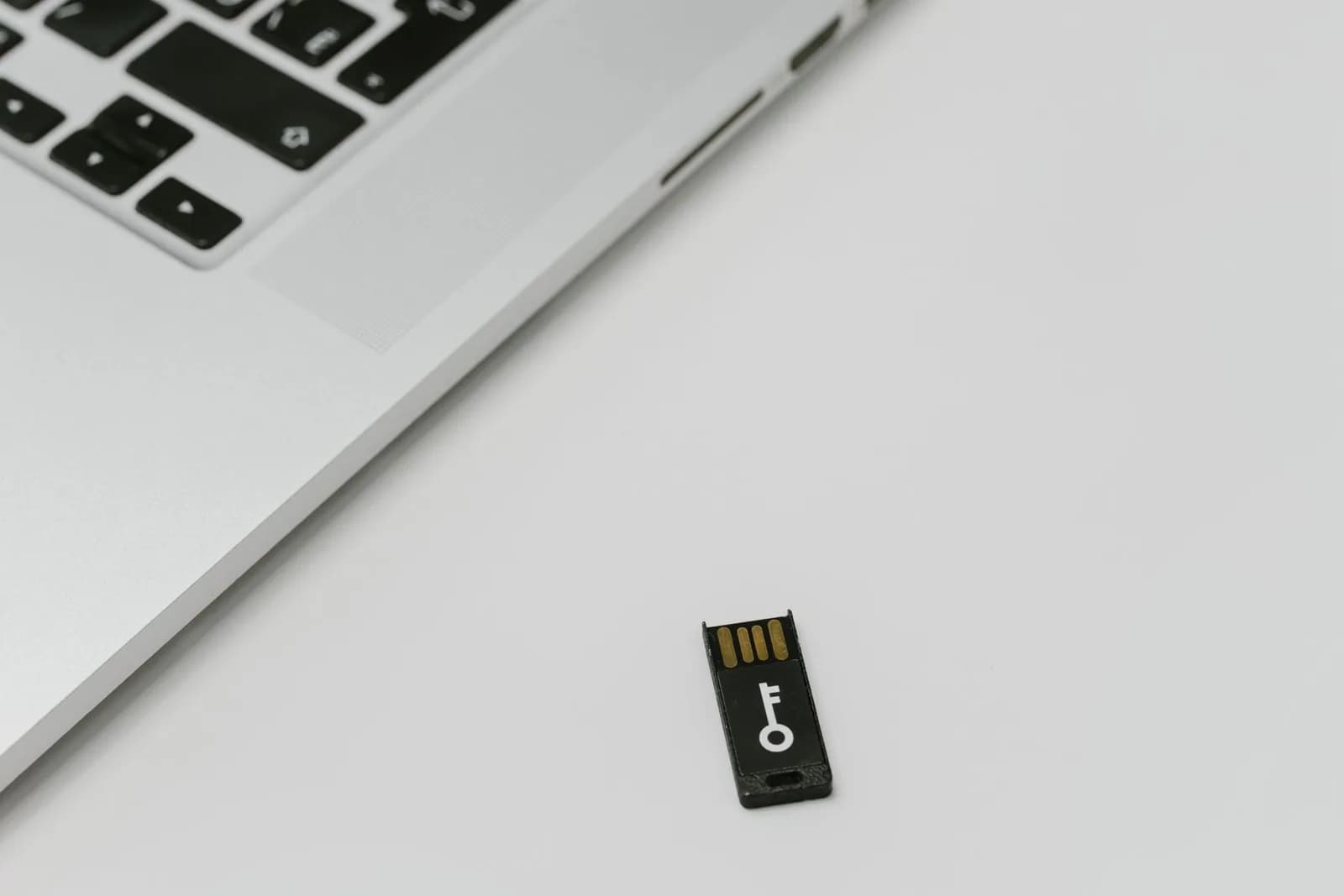 A USB device marked with a key symbol beside a laptop